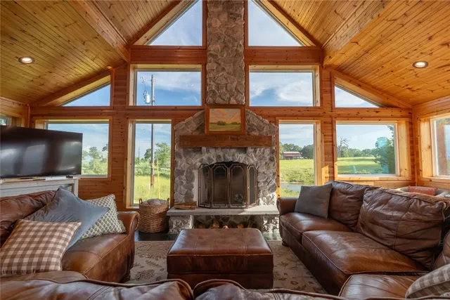 a living room with furniture a fireplace and a floor to ceiling window