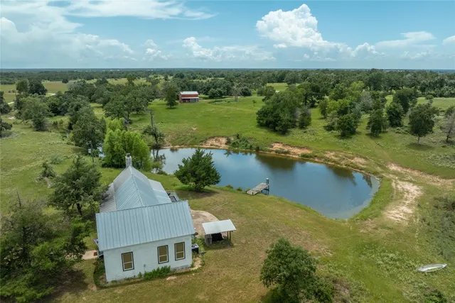 a aerial view of a house with a yard and lake view