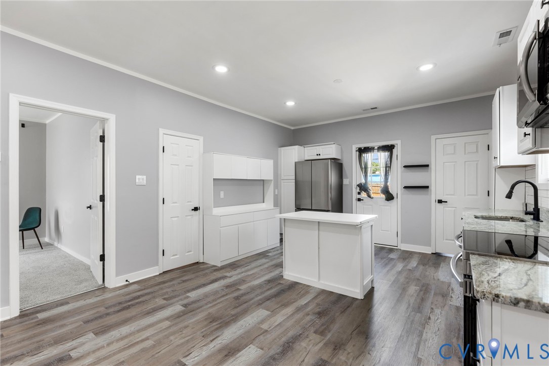 3061 Decatur Street Richmond, VA 23224 - Photo 11 of 23 a large white kitchen with white cabinets and wooden floor
