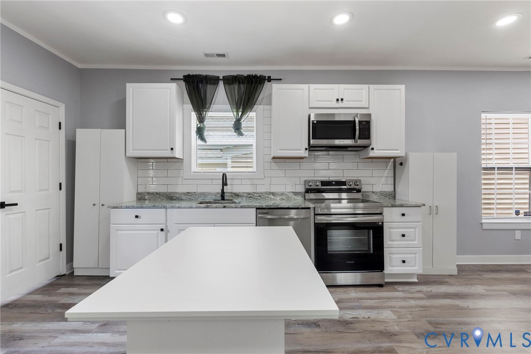 3061 Decatur Street Richmond, VA 23224 - Photo 12 of 23 a kitchen with stainless steel appliances a stove sink microwave and cabinets