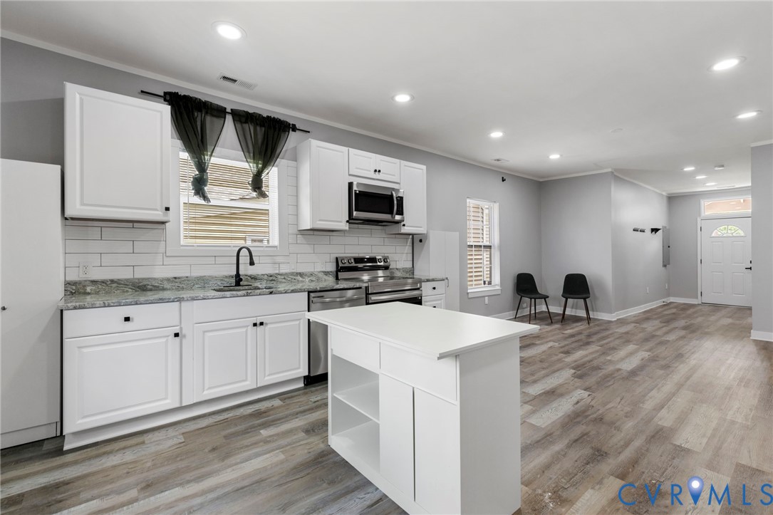 3061 Decatur Street Richmond, VA 23224 - Photo 13 of 23 a large kitchen with kitchen island granite countertop a sink and white cabinets