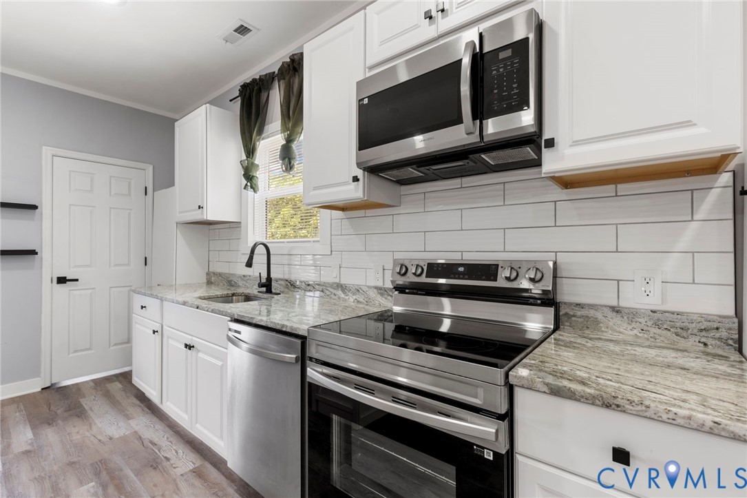 3061 Decatur Street Richmond, VA 23224 - Photo 15 of 23 a kitchen with stainless steel appliances granite countertop a stove and a microwave