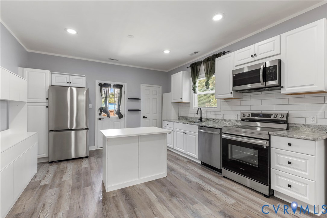 3061 Decatur Street Richmond, VA 23224 - Photo 10 of 23 a kitchen with stainless steel appliances a stove a sink and a microwave