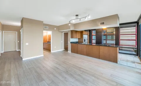 a view of a big room with wooden floor and windows