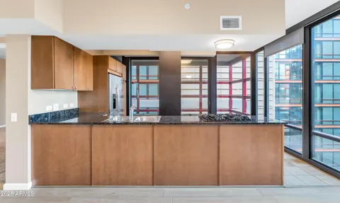 a view of a large mirror and wooden cabinets