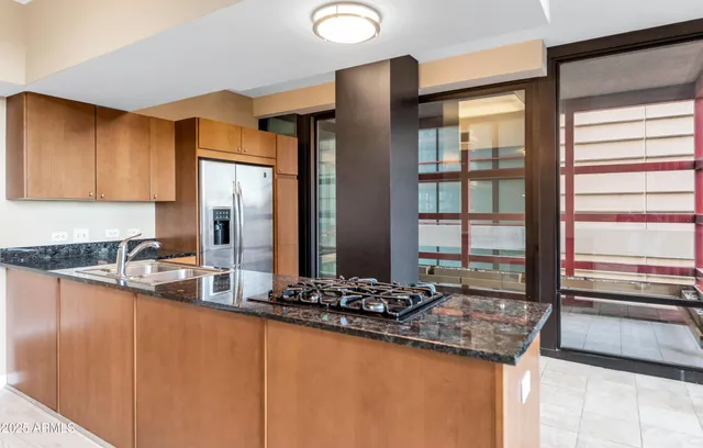 a kitchen with stainless steel appliances granite countertop a sink and a stove