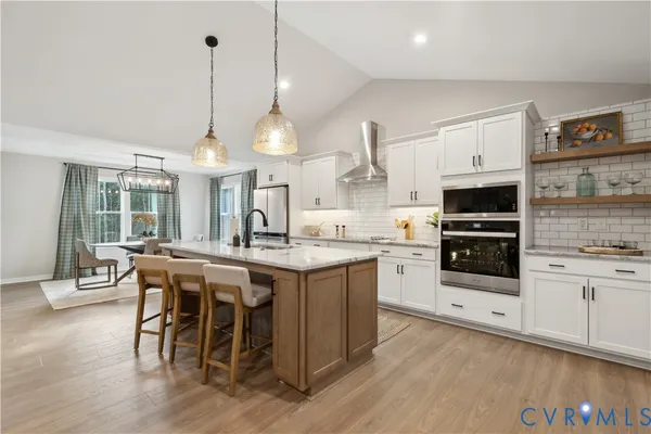 a kitchen with stainless steel appliances a stove center island a stove and a wooden floor