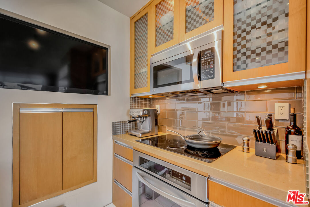 201 Ocean Avenue, Unit 1505B Santa Monica, CA 90402 - Photo 12 of 45 a kitchen with stainless steel appliances a stove a microwave and cabinets