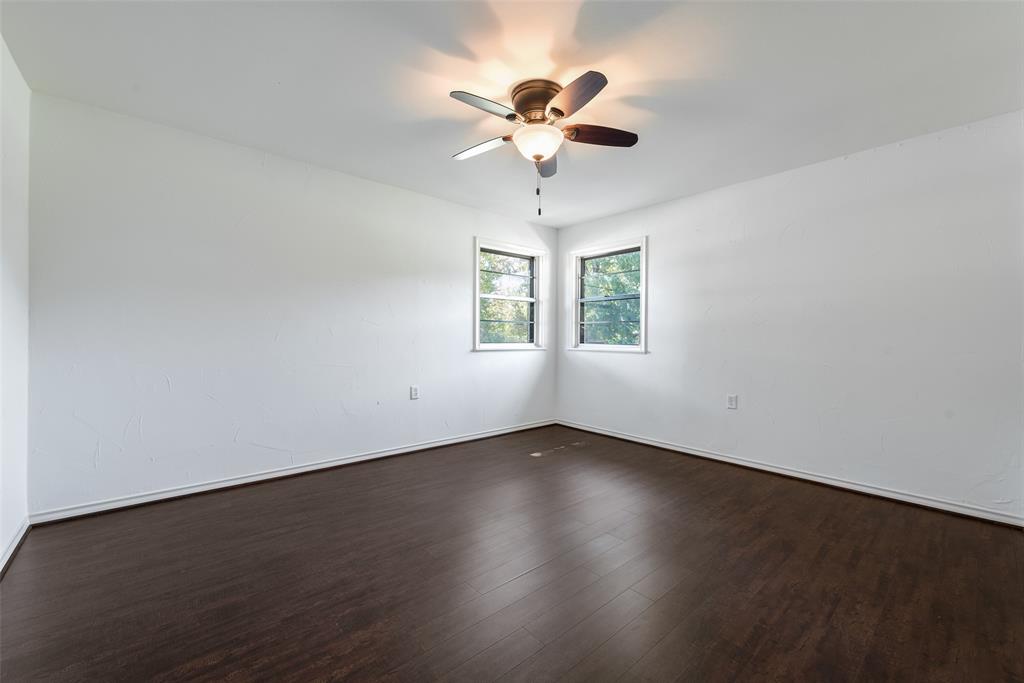 616 Laurel Road, Unit A Athens, TX 75751 - Photo 15 of 24 an empty room with wooden floor chandelier fan and windows