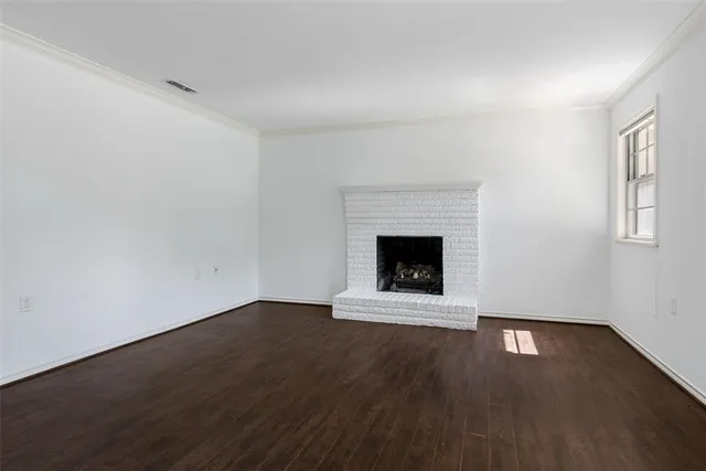 an empty room with wooden floor and fireplace