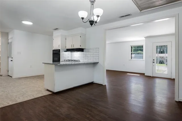 a view of kitchen with granite countertop cabinets and wooden floor