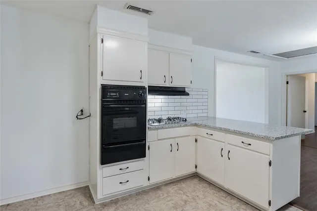 a kitchen with granite countertop white cabinets and white appliances