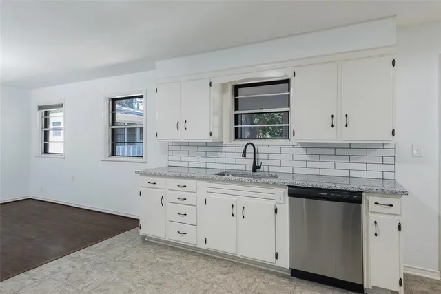 a kitchen with white cabinets and sink