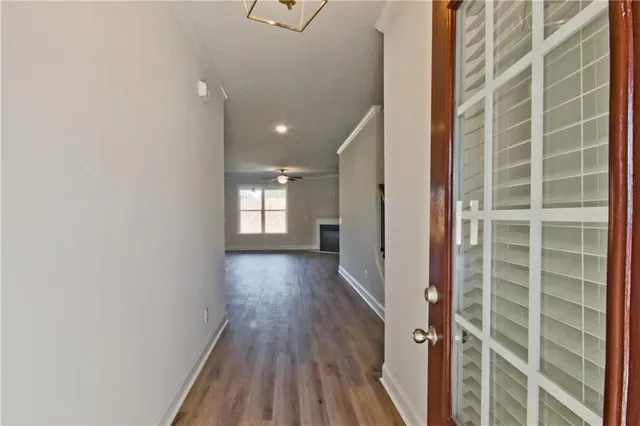 a view of a hallway with wooden floor and a window