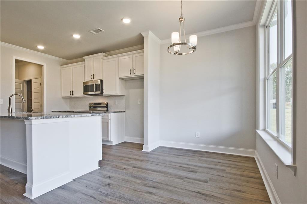 5984 Spring Way Lithonia, GA 30058 - Photo 11 of 37 a kitchen with kitchen island white cabinets and refrigerator