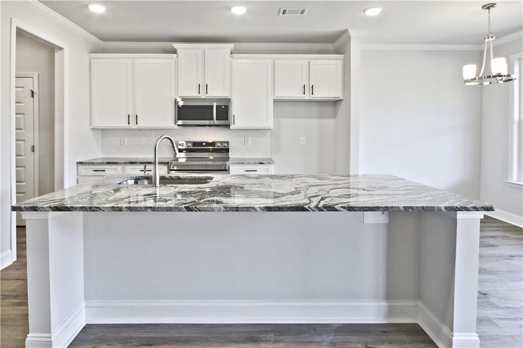 5984 Spring Way Lithonia, GA 30058 - Photo 13 of 37 a kitchen with granite countertop a sink a stove and cabinets