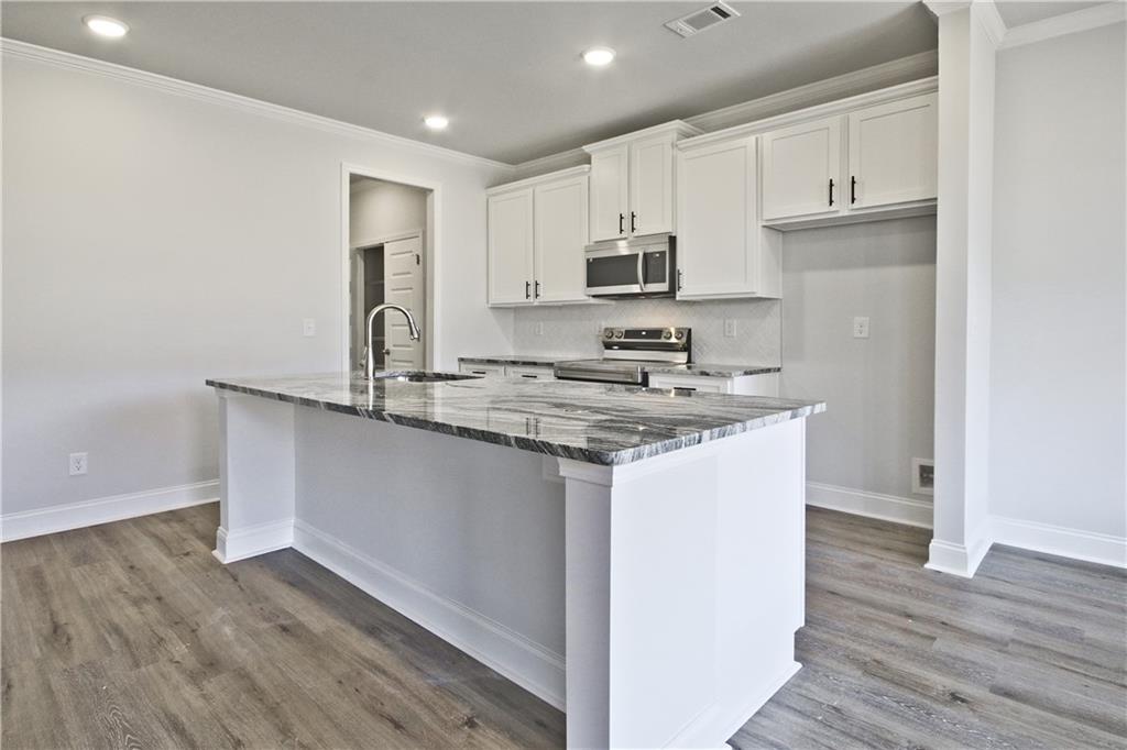 5984 Spring Way Lithonia, GA 30058 - Photo 14 of 37 a kitchen with stainless steel appliances granite countertop a sink stove and refrigerator