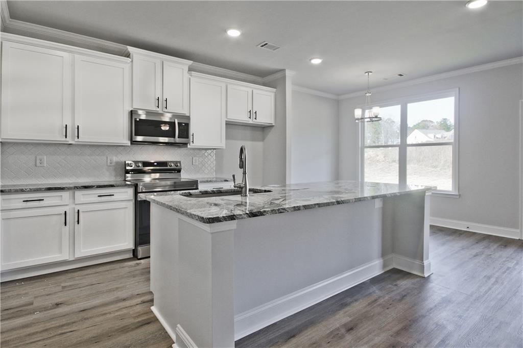 5984 Spring Way Lithonia, GA 30058 - Photo 15 of 37 a kitchen with stainless steel appliances granite countertop a stove a sink and a microwave