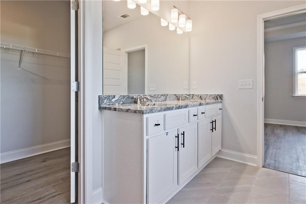 5984 Spring Way Lithonia, GA 30058 - Photo 24 of 37 a bathroom with a granite countertop sink a mirror and a vanity