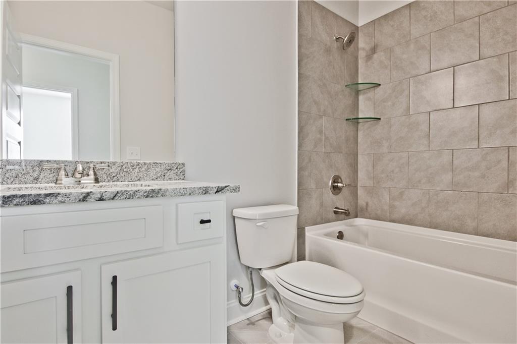 5984 Spring Way Lithonia, GA 30058 - Photo 32 of 37 a bathroom with a granite countertop toilet a sink and a bathtub