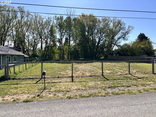 a view of a yard with wooden fence