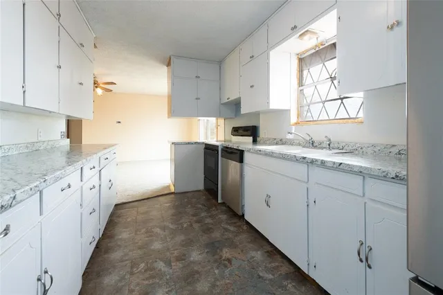 a kitchen with granite countertop sink stainless steel appliances and cabinets