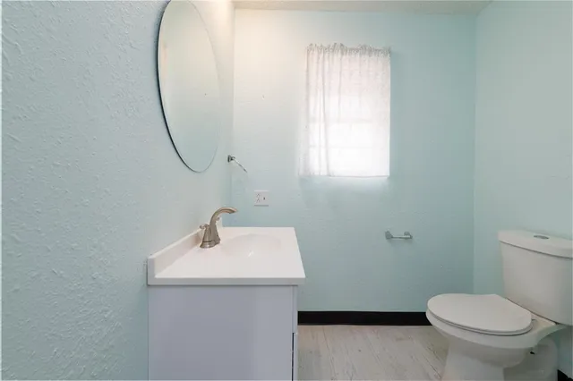 a bathroom with a sink a toilet and a mirror