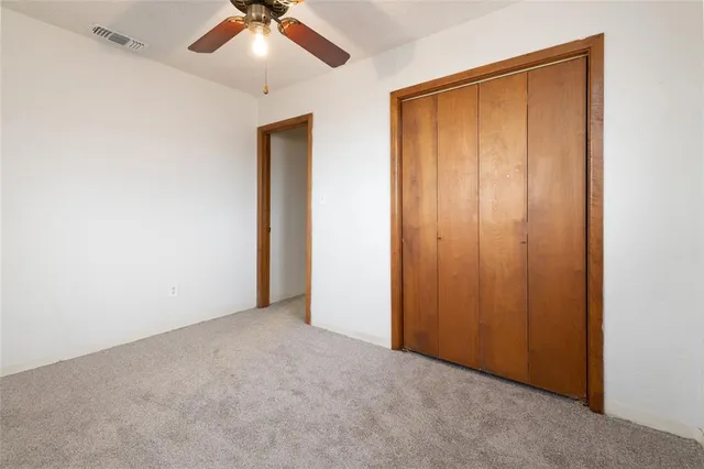 an empty room with chandelier fan