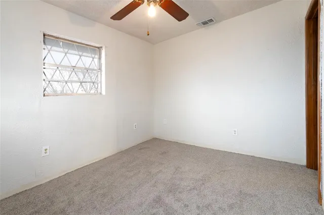 an empty room with chandelier fan