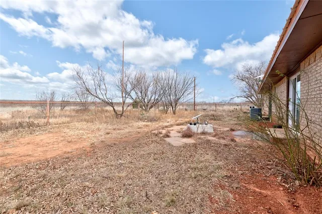 a view of a yard with wooden fence