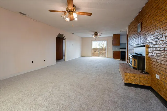 a view of an empty room with a fireplace and a window
