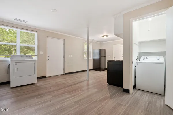 a kitchen with granite countertop stainless steel appliances a stove top oven a refrigerator a sink and dishwasher with wooden floor