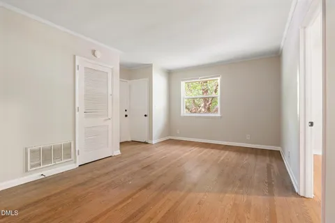 a view of a room that has wooden floor and window in it