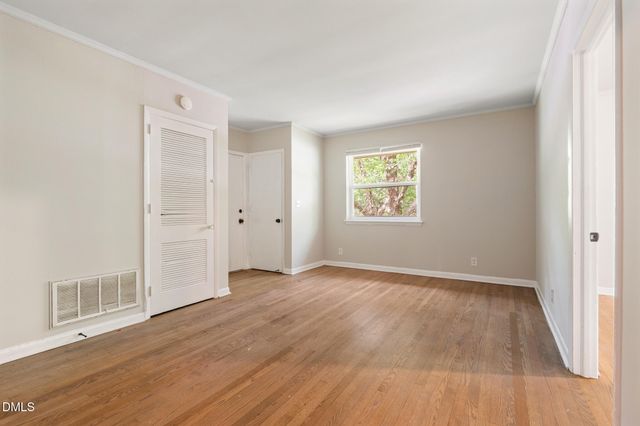 a view of a room that has wooden floor and window in it
