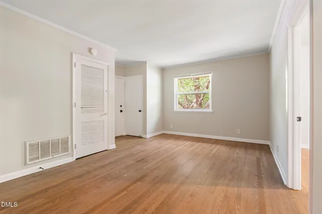a view of a room that has wooden floor and window in it