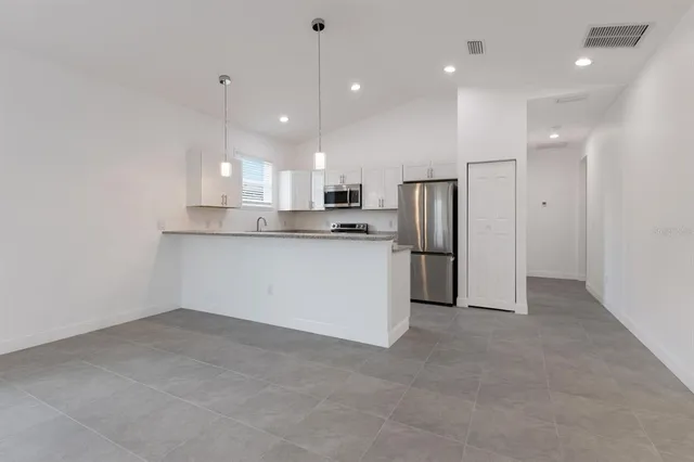 a view of kitchen with refrigerator and microwave