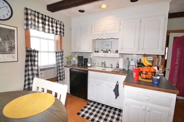 a kitchen with stainless steel appliances a refrigerator a sink a stove and white cabinets