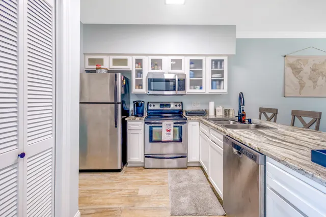 a kitchen with stainless steel appliances granite countertop a refrigerator and a stove top oven