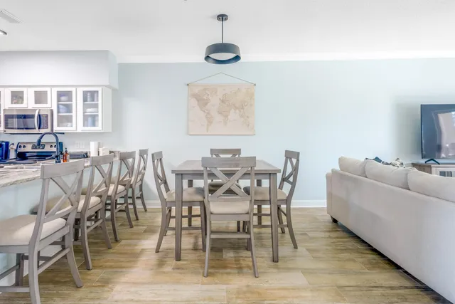 a dining room with furniture a chandelier and wooden floor