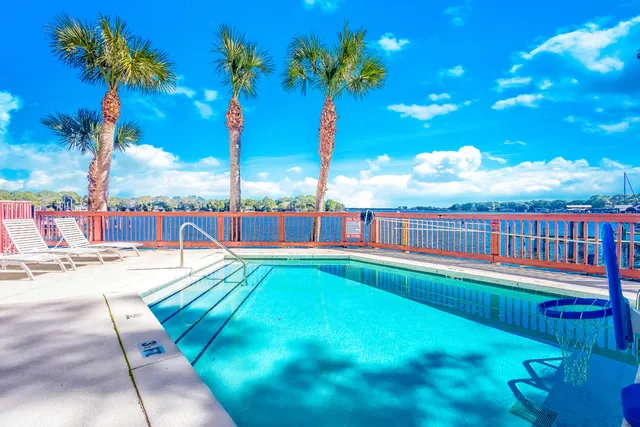 a view of a swimming pool with a bench and tables