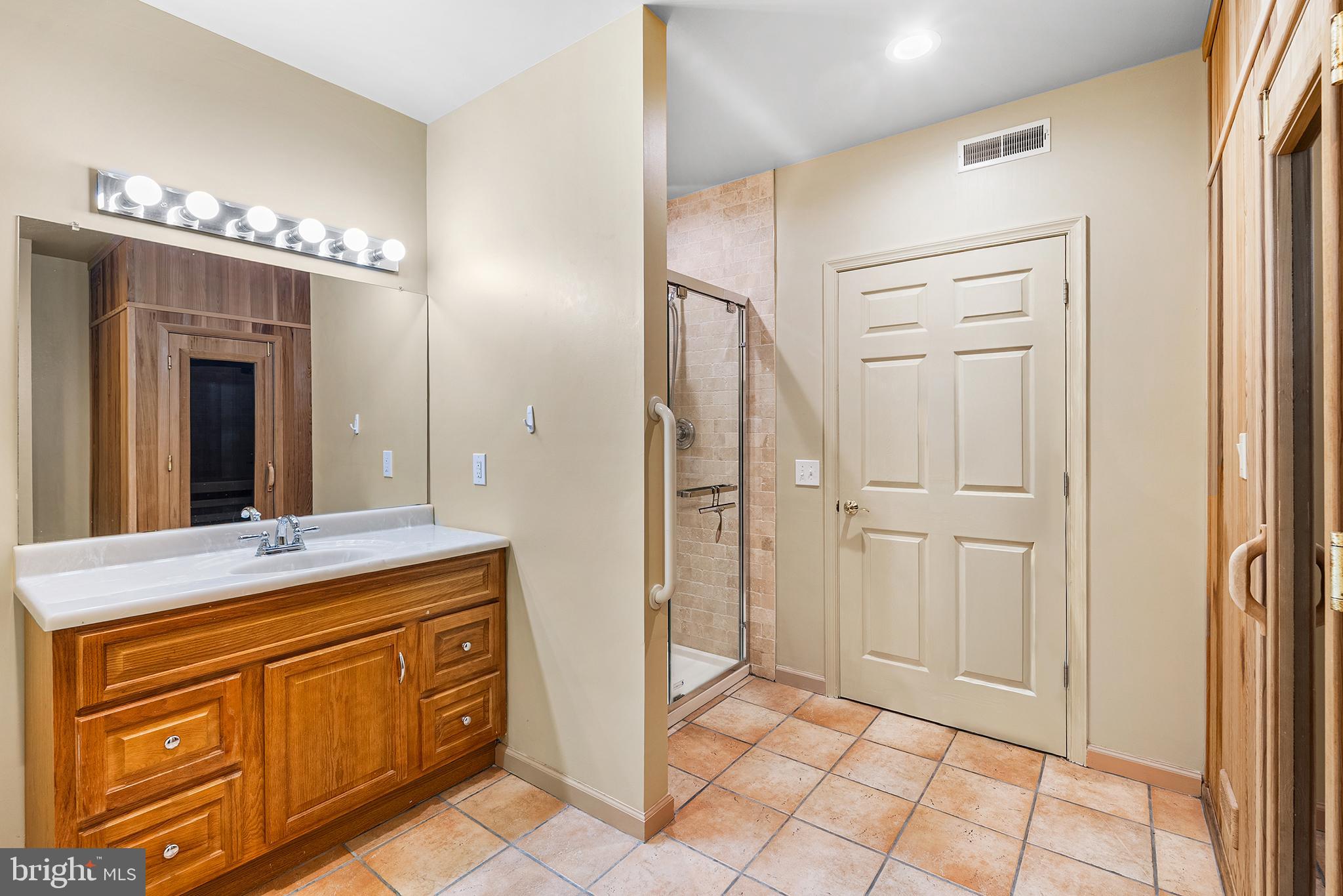 2000 St Andrews Drive Berwyn, PA 19312 - Photo 38 of 44 a spacious bathroom with a granite countertop sink a mirror and a shower