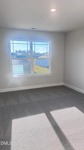 a view of empty room with window and ceiling fan