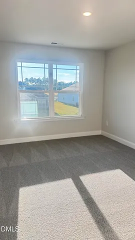 en empty room with windows and ceiling fan