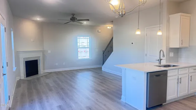a kitchen with a white stove top oven and wooden floor