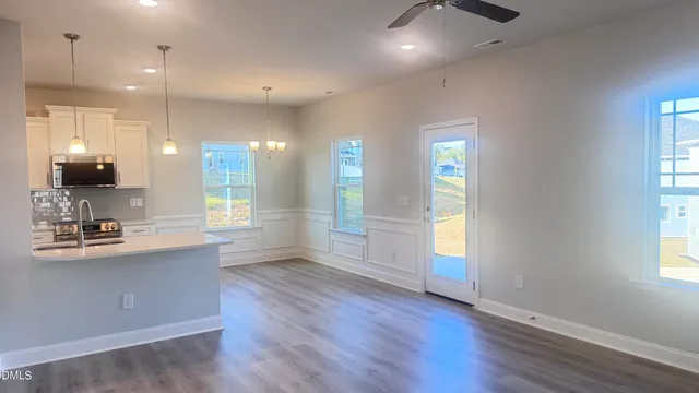 a kitchen with stainless steel appliances a sink a stove a microwave a center island and a window