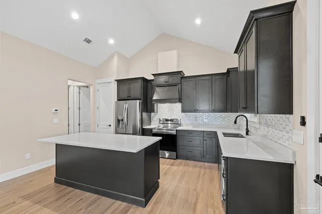 a large kitchen with stainless steel appliances kitchen island granite countertop a sink and cabinets