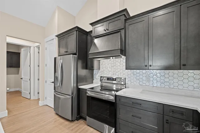 a kitchen with stainless steel appliances granite countertop a refrigerator and a sink