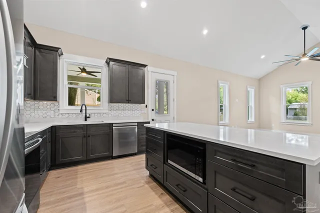 a kitchen with stainless steel appliances granite countertop a sink and stove top oven