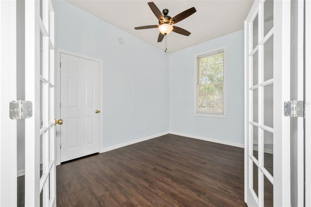 5213 Southwest 91 Terrace, Unit B Gainesville, FL 32608 - Photo 17 of 38 a view of empty room with wooden floor and fan
