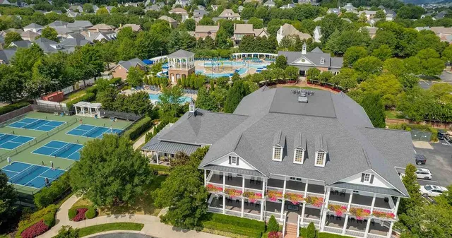 an empty room with wooden floor fireplace and windows